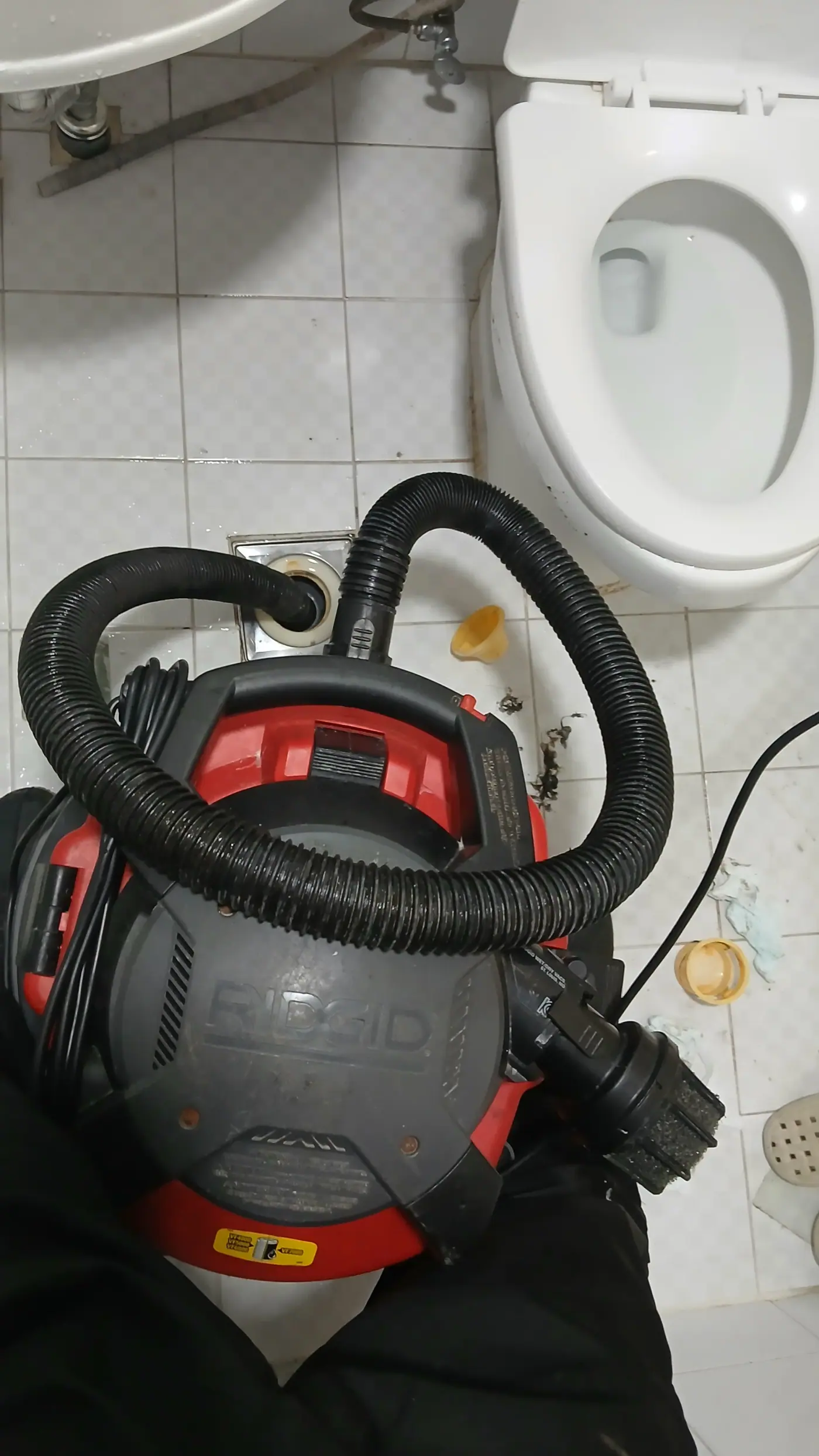 RIDGID 대용량 산업용 진공 석션기로 화장실 하수구 이물질을 흡입하는 작업 모습